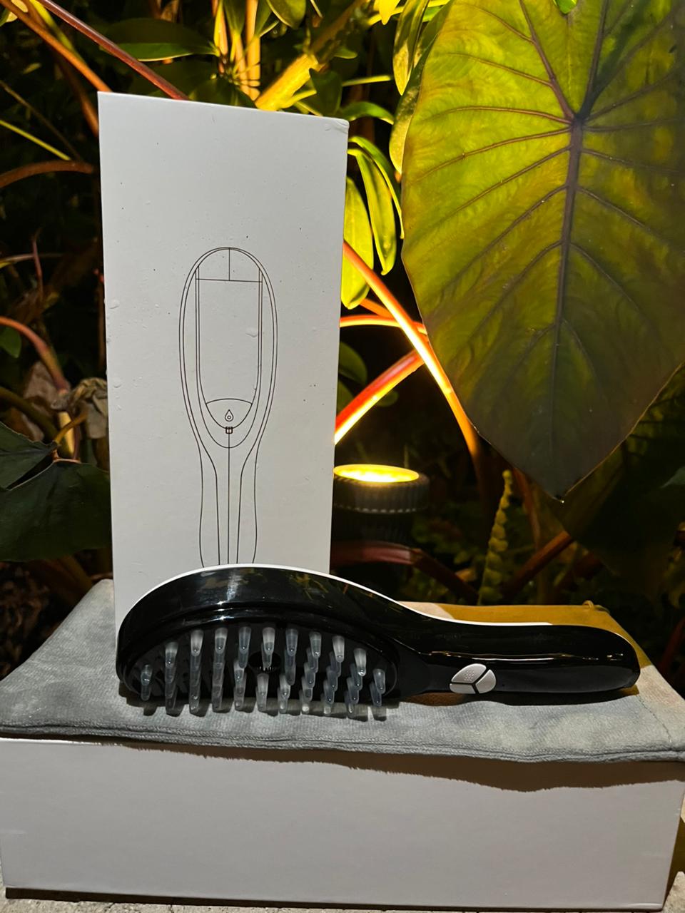 Cepillo electrónico reparador con aceite sobre caja blanca